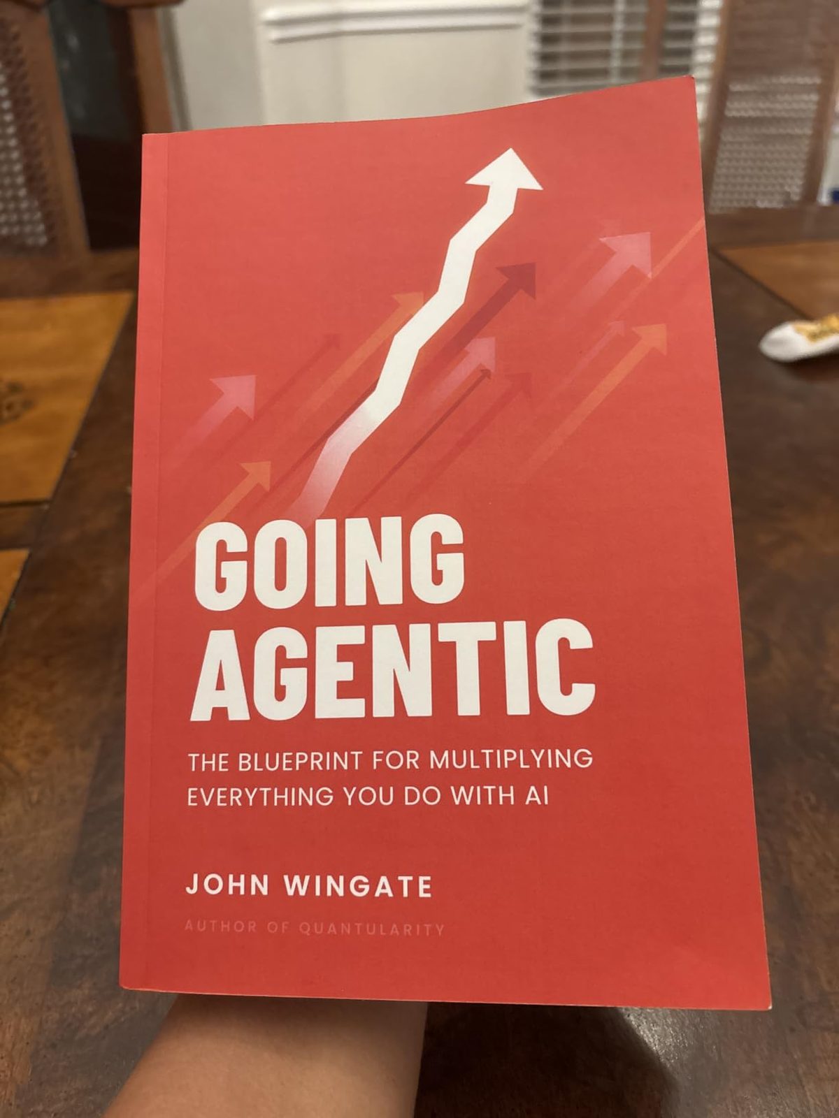 A reader holding Going Agentic at a table