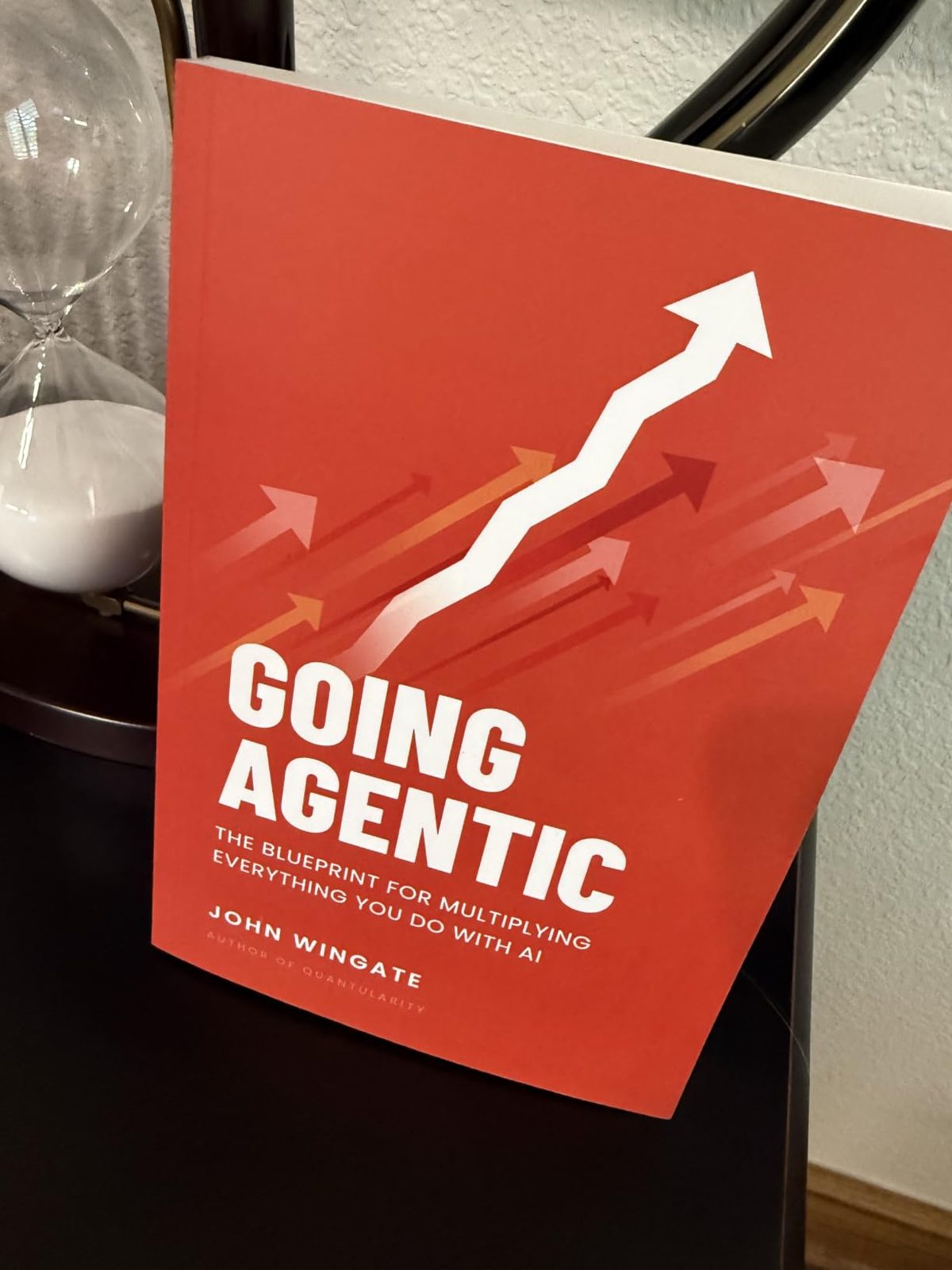 Going Agentic propped beside an hourglass