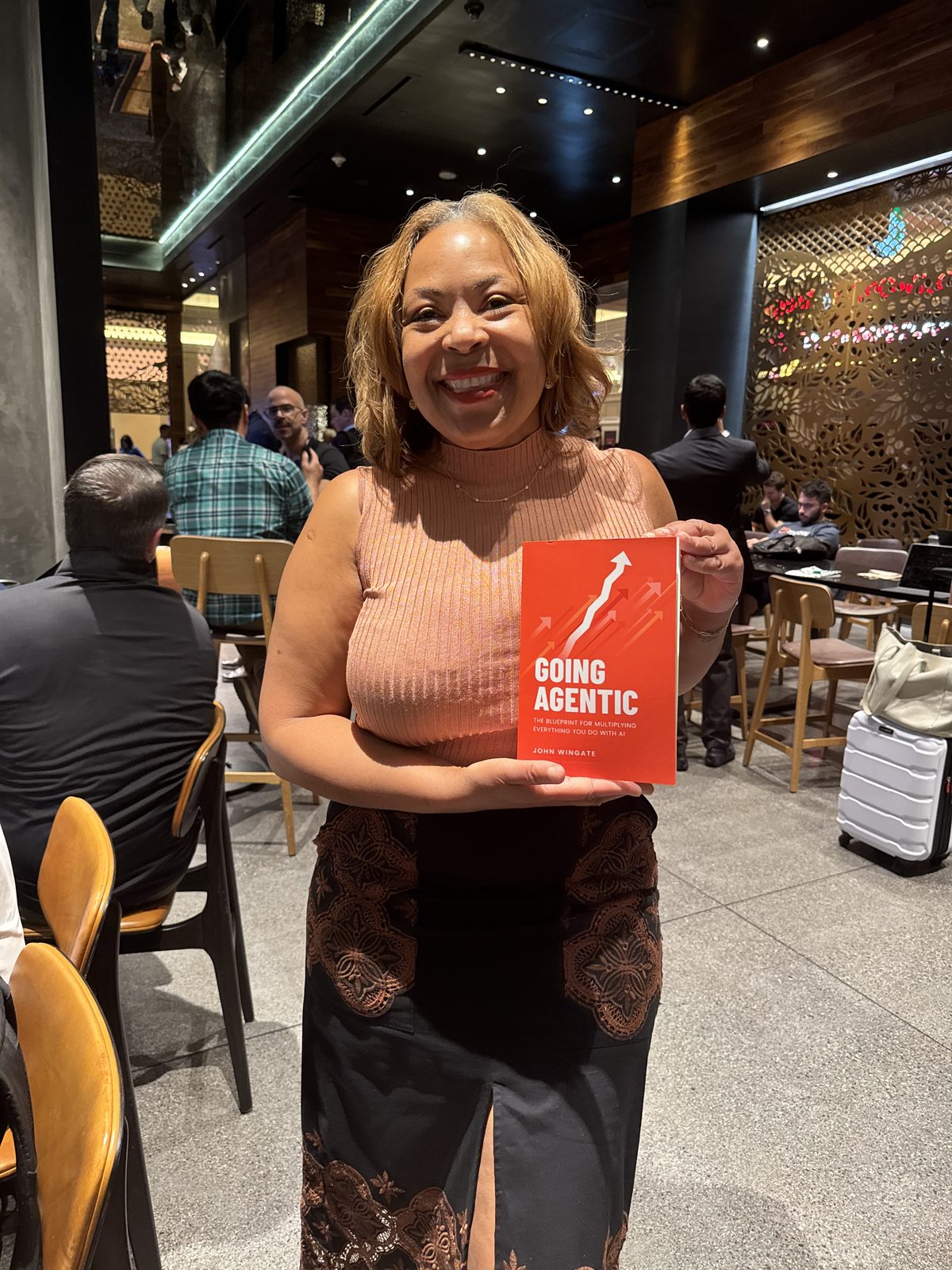 A reader smiling with Going Agentic at a lounge