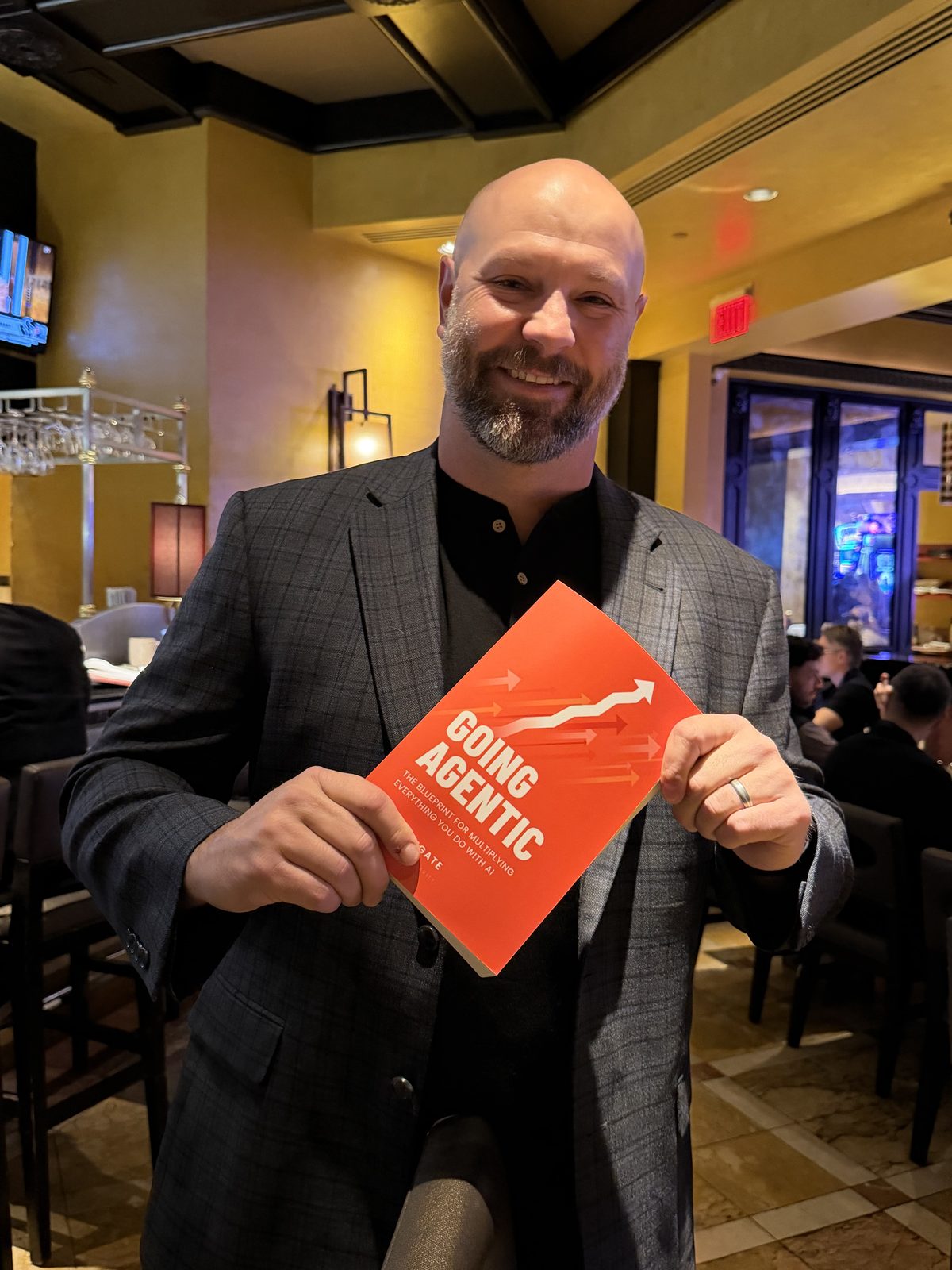 A reader holding Going Agentic at a restaurant