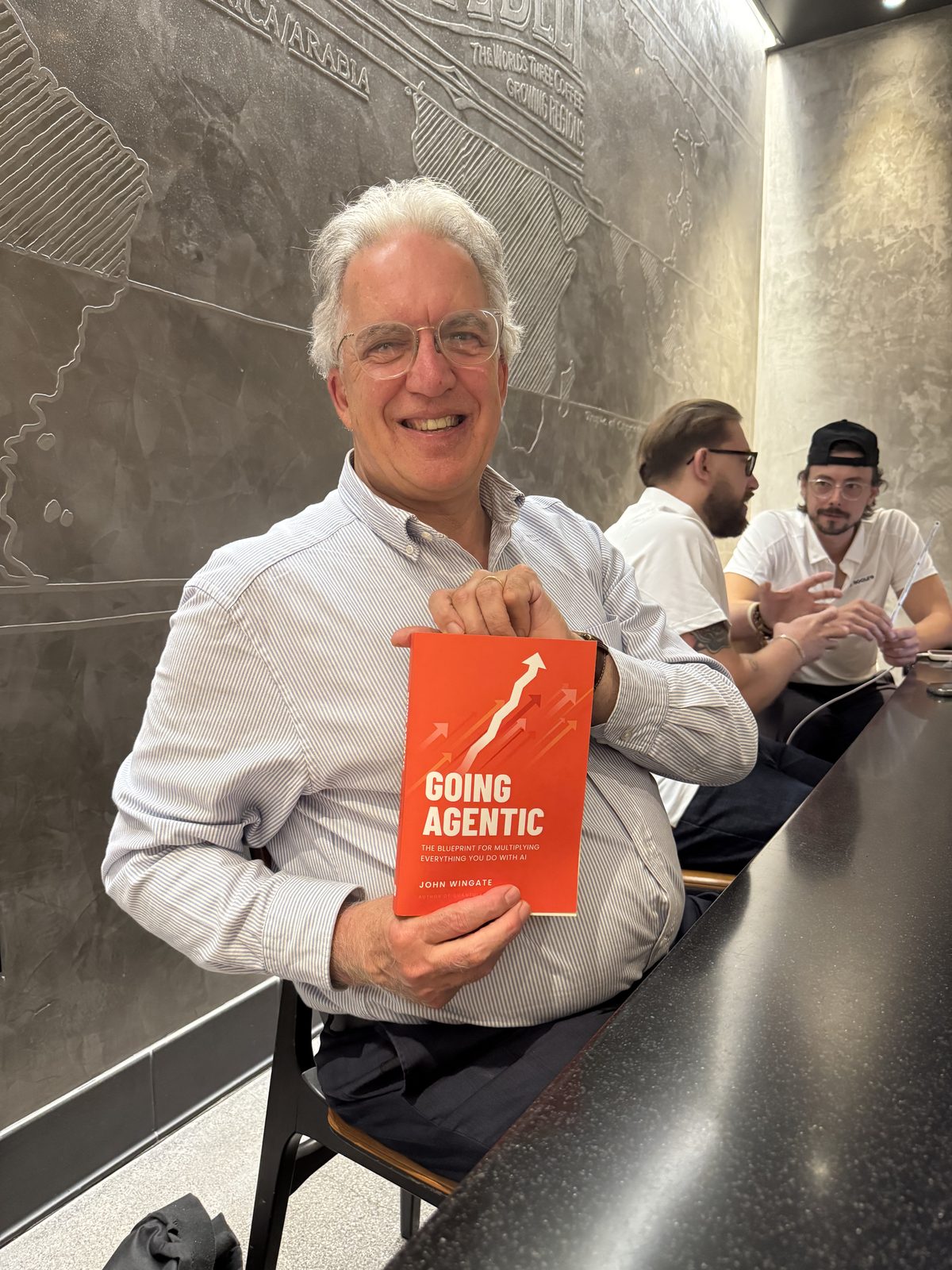 A reader smiling with Going Agentic at a cafe